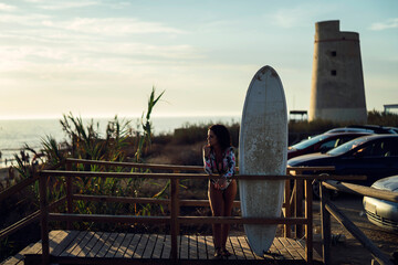 Fototapeta na wymiar Chica joven guapa surfeando en playas de cadiz,andalucia