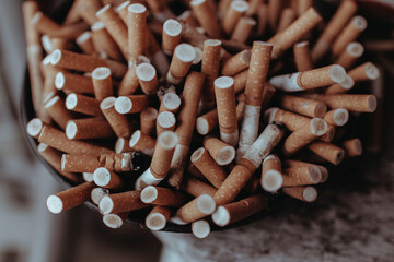 An over filled ash tray filled with cigarette butts.