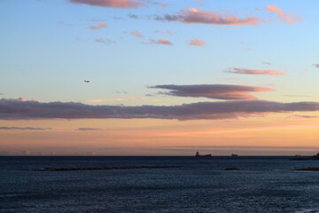 Sea view with sunset sky with ships and plane in the distance