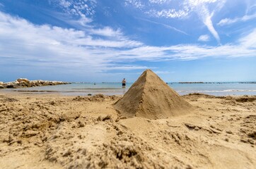 Fototapeta na wymiar Sand pyramid on the beach by the sea