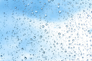 Naklejka na ściany i meble Blue water drops on glass or rain drop background 