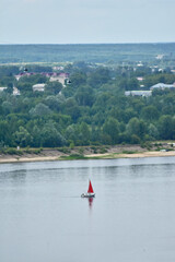 Fototapeta na wymiar yacht with red sail sails on the Volga River
