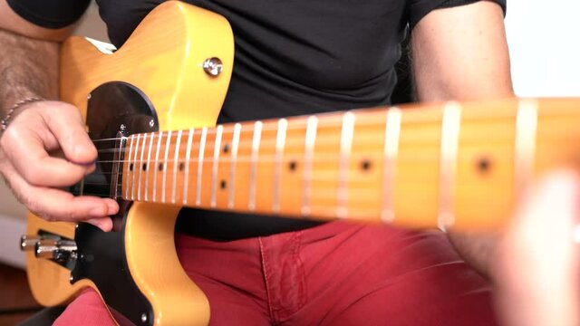MANI DI UOMO ADULTO SUONANO CHITARRA ELETTRICA FACENDO ARPEGGI E NOTE MUSICALI 