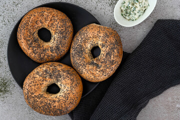 Bagels on a black plate arranged on a marble counter
