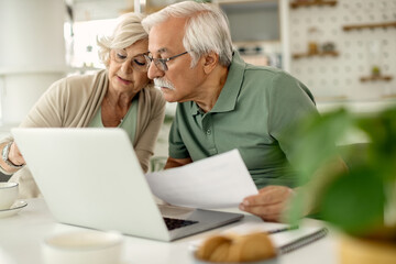 Senior couple analyzing their savings while going through home finances.