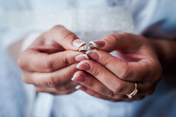 the bride holds a gold ring in her hands