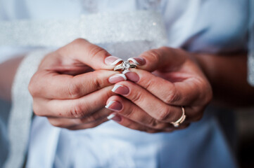 the bride holds a gold ring in her hands