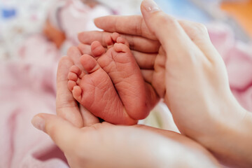 Obraz na płótnie Canvas Little baby feet in mother's hand 
