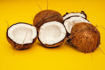 Parts of coconut on a colored background. Close up. Fresh ripe coconut broken into pieces.