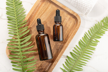 Essential oil bottle on wooden tray. Beauty, skin care, wellness