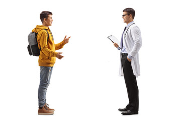 Full length profile shot of a teenage boy talking to a male doctor