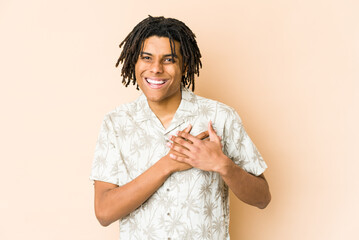 Young african american rasta man has friendly expression, pressing palm to chest. Love concept.