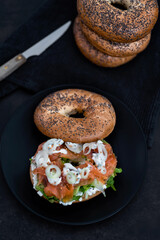 Salmon Lox Bagel with cream cheese and veggies on a dark setting