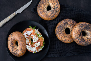 Salmon Lox Bagel with cream cheese and veggies on a dark setting