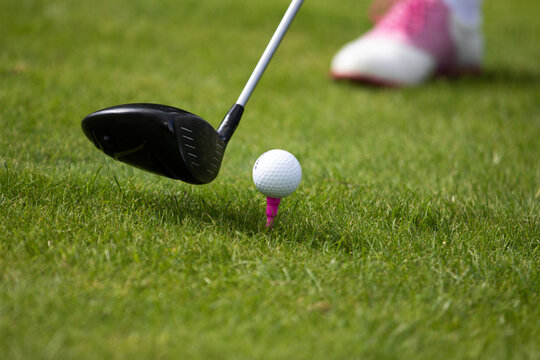 A golfer prepares to hit the ball with a driver