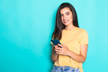Young woman use phone isolated on turquoise background