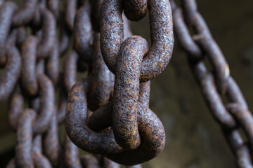 Detail of a worn and rusty link in a large chain.