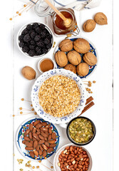 Ingredients for making granola. Rolled oats, nuts, berries and honey on a white background top view.  Tasty and healthy food.