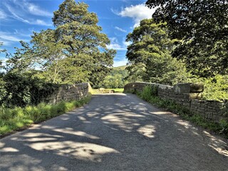 Old stone bridge, with old trees and fields in the distance on, Eshington Lane, Burton cum Walden, Leyburn, UK