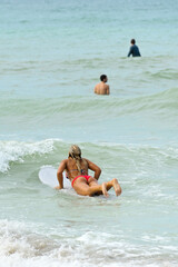 Fototapeta na wymiar Young Woman Surfing with Friends