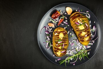 Freshly baked hasselback potatoes with chive. Appetizing potato accordion baked in the oven.