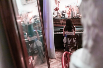 Rear mirror view of a girl playing the piano and singing