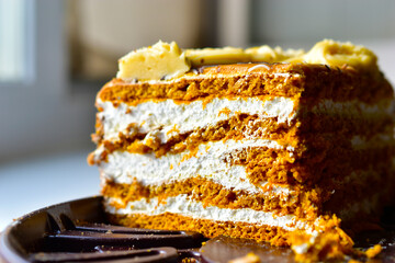 A piece of honey cream dark cake close up