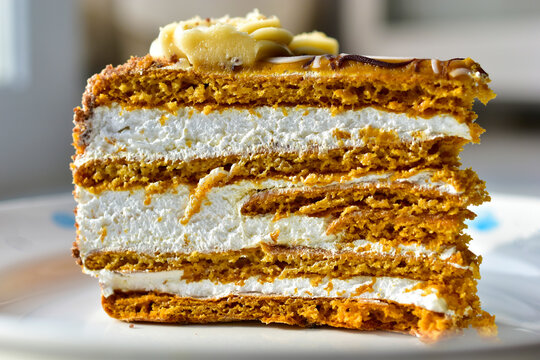 A piece of honey cream dark cake close up