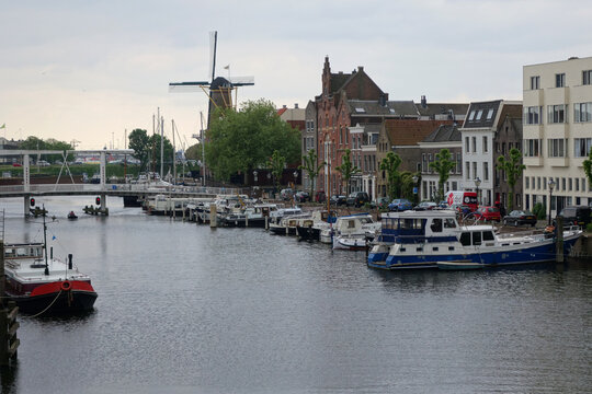 old historic district Delfshaven with wildmill and houseboats in Rotterdam, South Holland, The Netherlands. Summer sunny day.