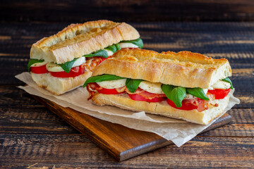 Caprese sandwich with tomatoes, mozzarella, basil and bacon. Healthy eating. Italian cuisine.