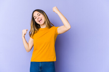 Fototapeta na wymiar Young caucasian woman isolated on purple background cheering carefree and excited. Victory concept.