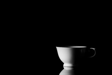 white ceramic coffee cup in the dark.