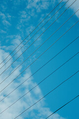 Telephone wires against the sky and clouds