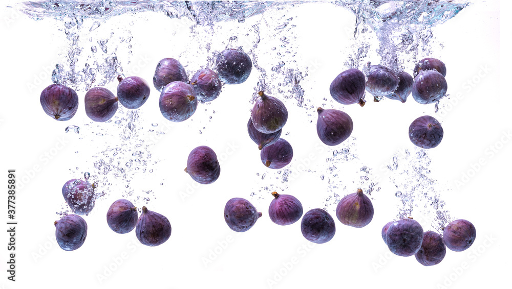 Wall mural Fresh figs falling into the water isolated on white background. Food photography.