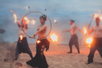 Group of fire artists fakir perform amazing show at night with flamethrowers, fire dancers, chain of fire, extreme breathing