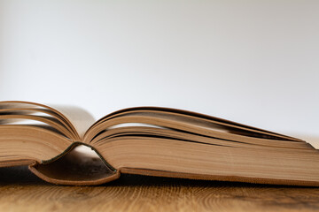 Open book on a wooden table with a white background