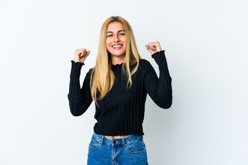 Young blonde woman isolated on white background celebrating a victory, passion and enthusiasm,...