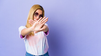 Young hipie woman with glasses isolated on purple background doing a denial gesture