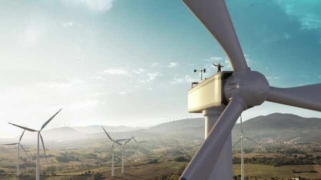 Happy engineer feel success after good work. He standing a top of windmill and looking beautiful sunset landscape