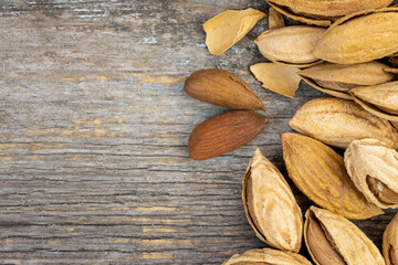 Almond with peel on a rustic wooden table.