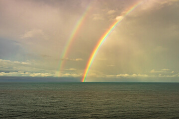 rainbow colorful above sea horizon at dawn