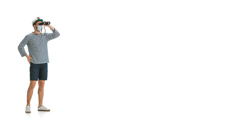 Man with binoculars. Caucasian male sailor in uniform on white studio background. Young man using modern devices and gadgets. Concept of tech, professional occupation, job of seaman, emotions. Flyer