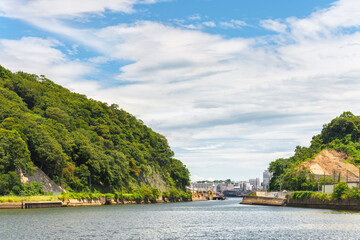 yokosuka, japan - july 19 2020: Arai Canal Waterway between Azuma Island and Yokosuka city separating the Japan Self Defence Fleet from the United States Seventh Fleet in the Yokosuka Naval Port.