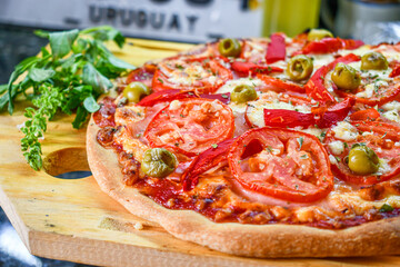 Pizza artesanal de rebanadas de tomate y aceitunas al estilo Uruguay