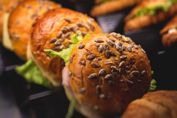 Beautifully decorated catering banquet table with different food snacks and appetizers with sandwich, burger and croissant  on corporate christmas birthday kids party event or wedding celebration