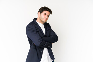 Young business man isolated on white background suspicious, uncertain, examining you.