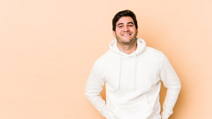 Young man isolated on beige background happy, smiling and cheerful.