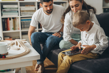 cute young family spending time together using tablet computer at home