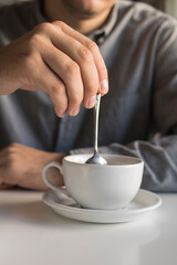 
The guy is drinking tea while sitting in a cafe