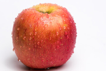 Variegated apple red and yellow with water drops on white background. Health and freshness concept
